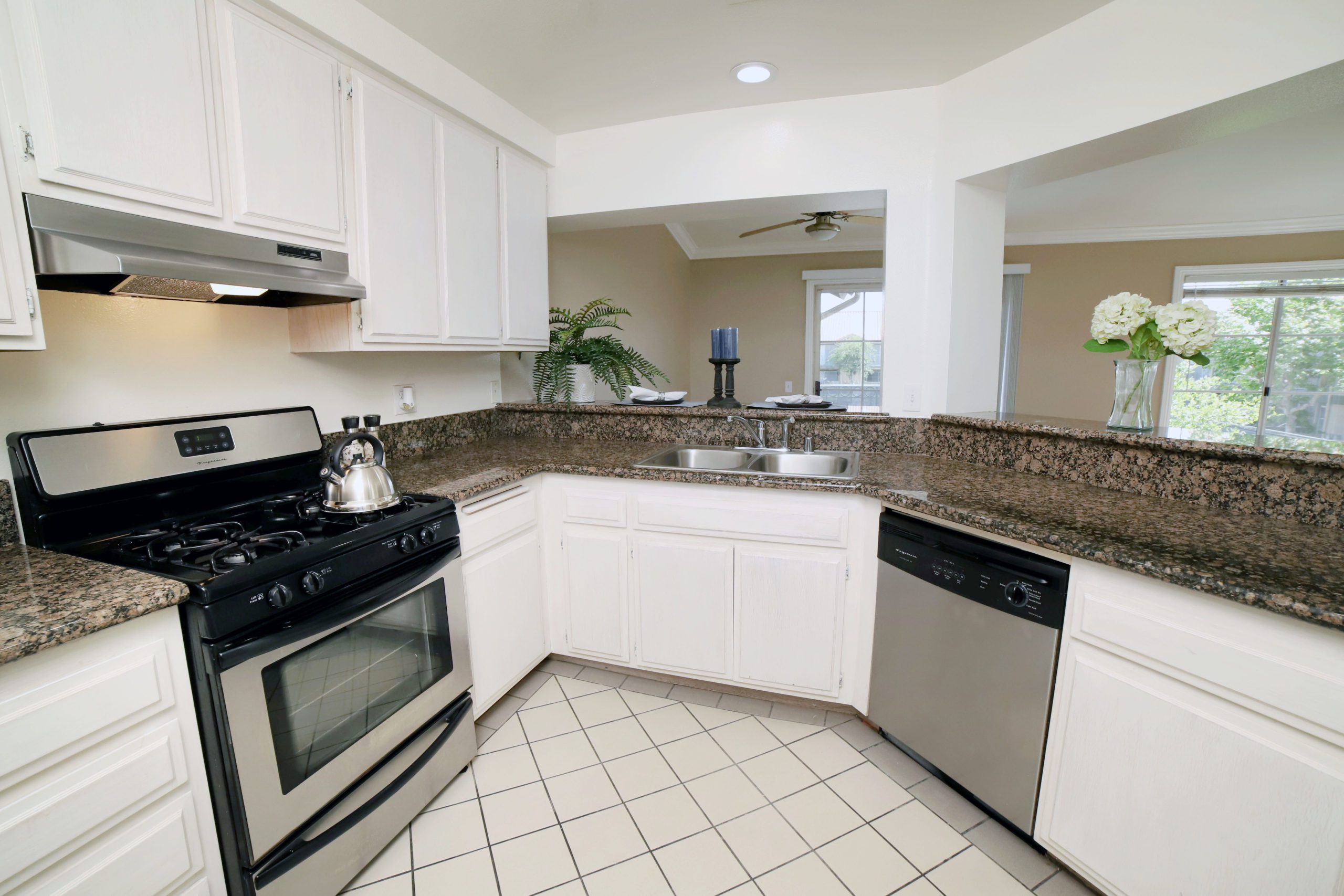 Apartments for Rent in Anaheim - Le Med - Kitchen with Whitewashed Cabinets, Granite Countertops, Stainless Steel Appliances, and Ceramic Tile Floors